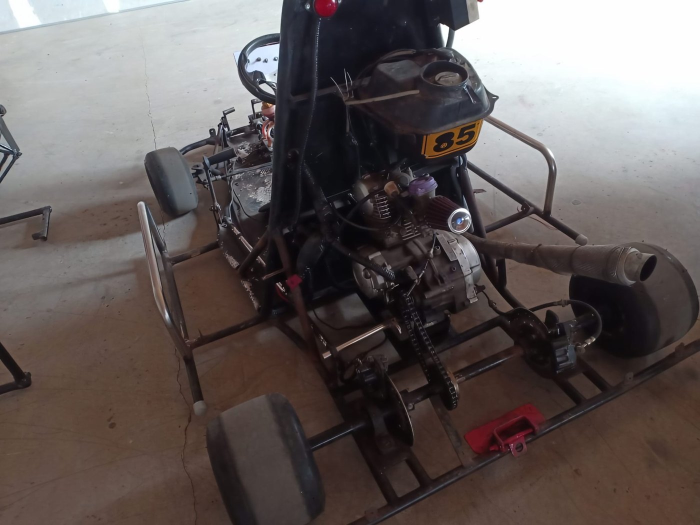 Bare go-kart chassis showing frame, engine mounting and chain drive